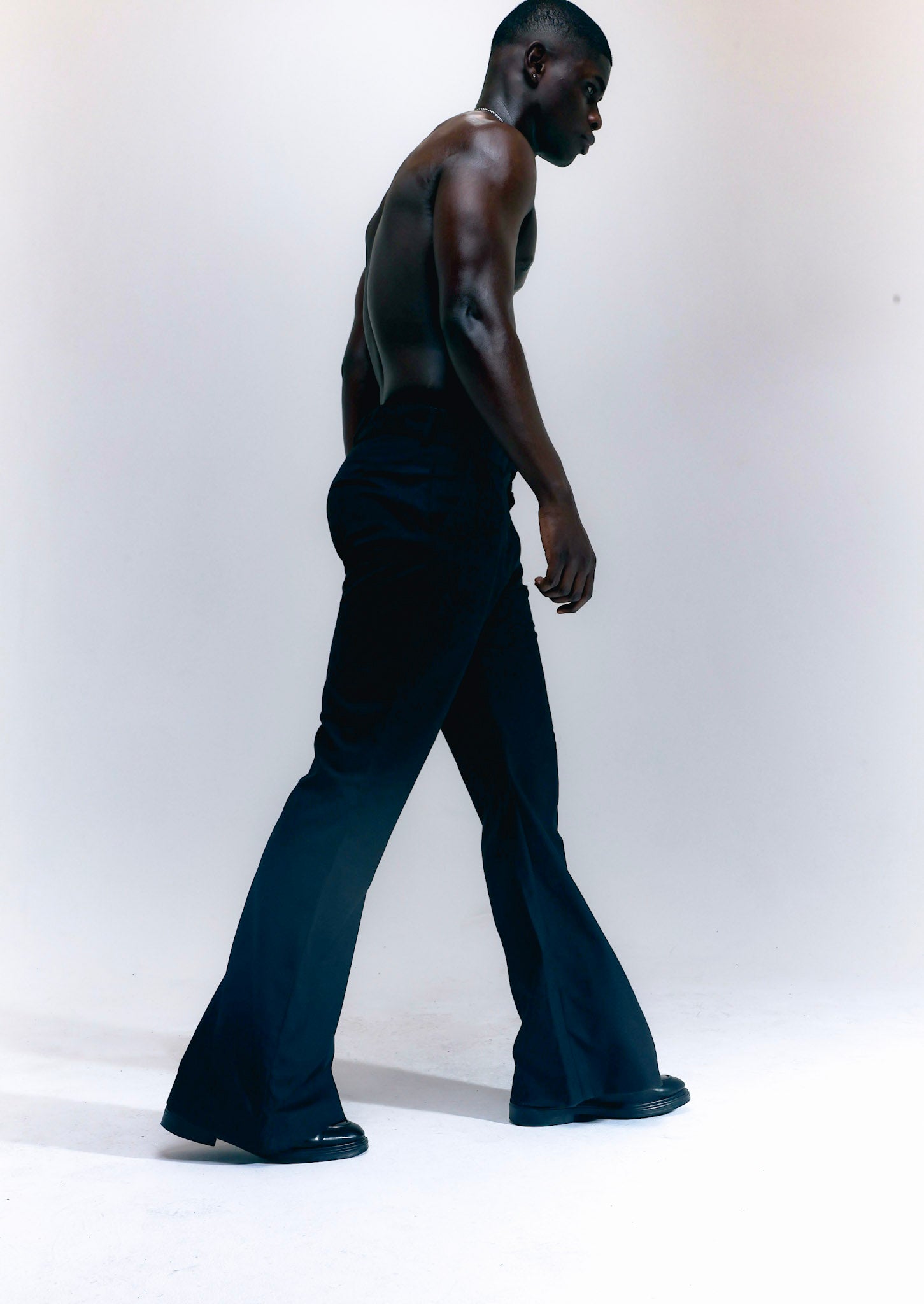 Men wearing black flare pants with vintage 70s bell bottom silhouette