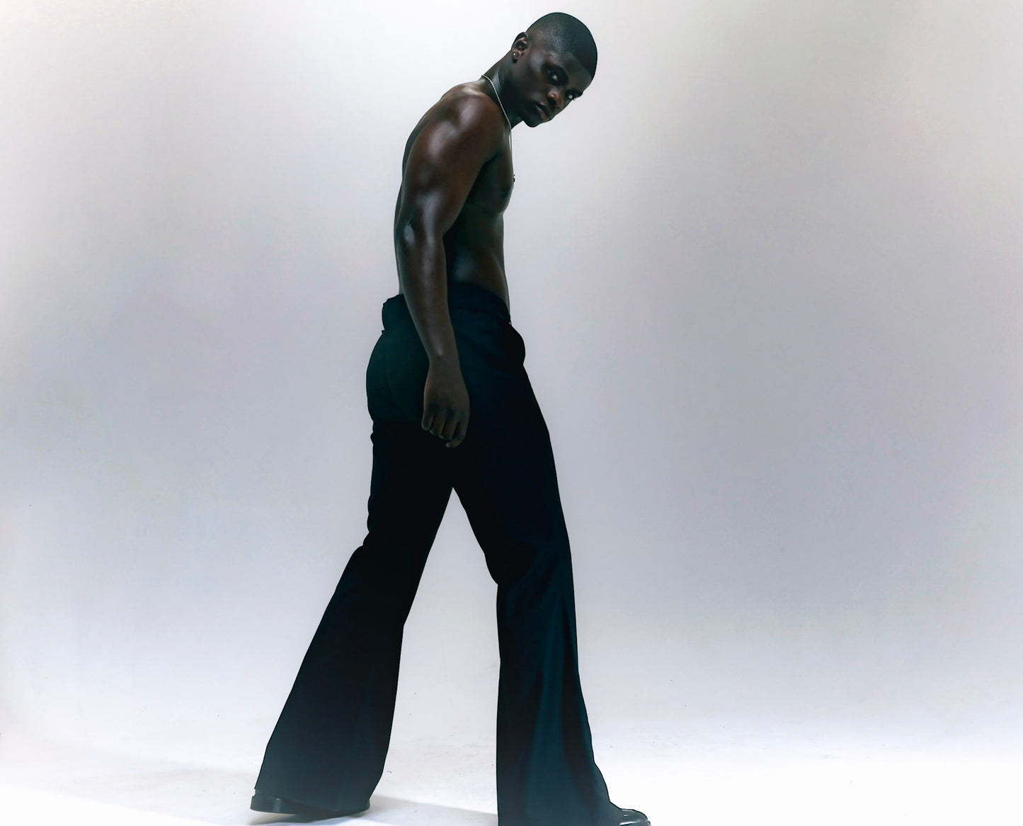 Men wearing black flare pants with vintage 70s bell bottom silhouette