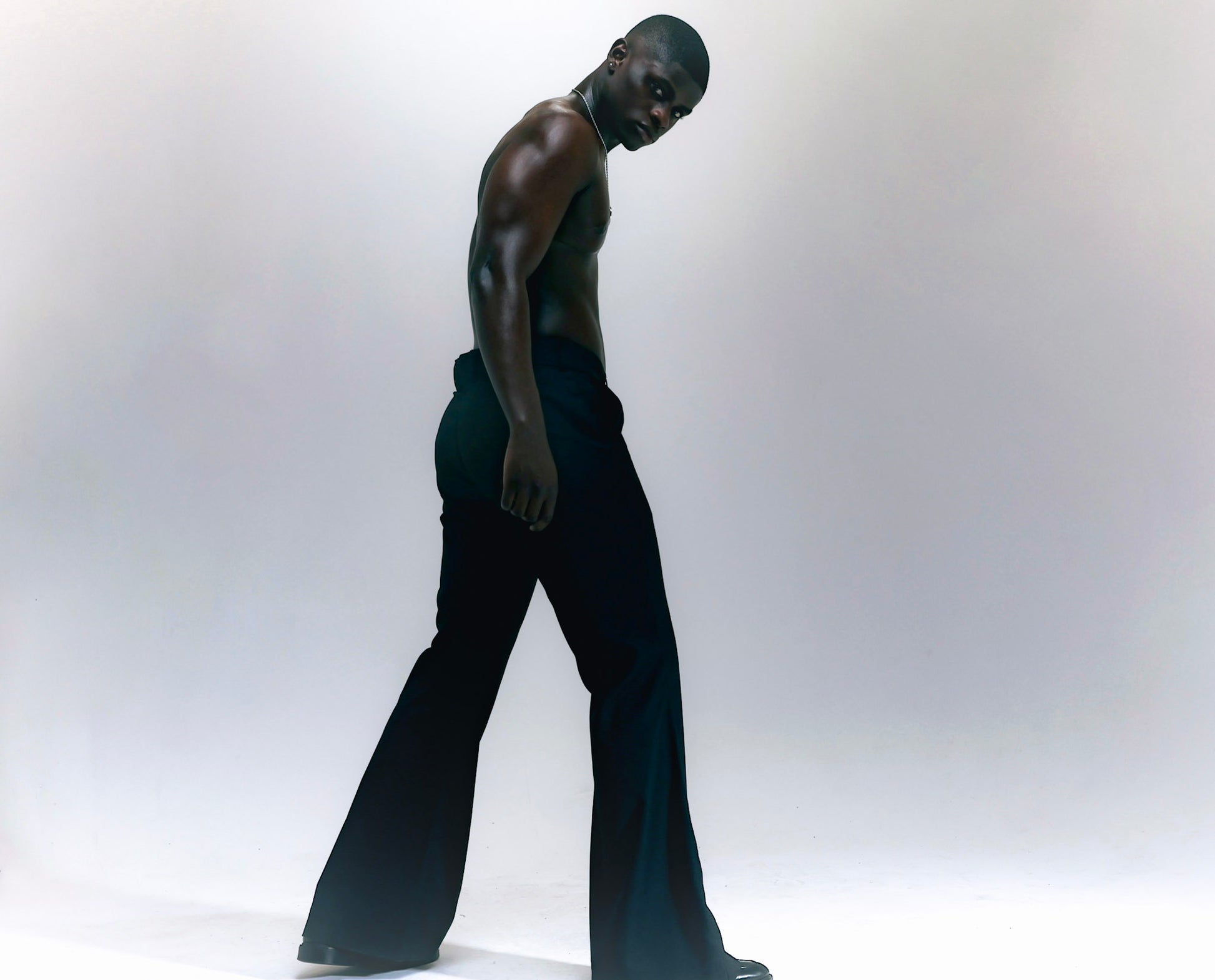 Men wearing black flare pants with vintage 70s bell bottom silhouette